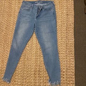 Blue skinny jeans with frayed bottoms